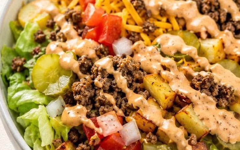 Salade Big Mac dans un bol : laitue, bœuf haché, cornichons, tomates, oignons et patates en dés, nappés de sauce Big Mac