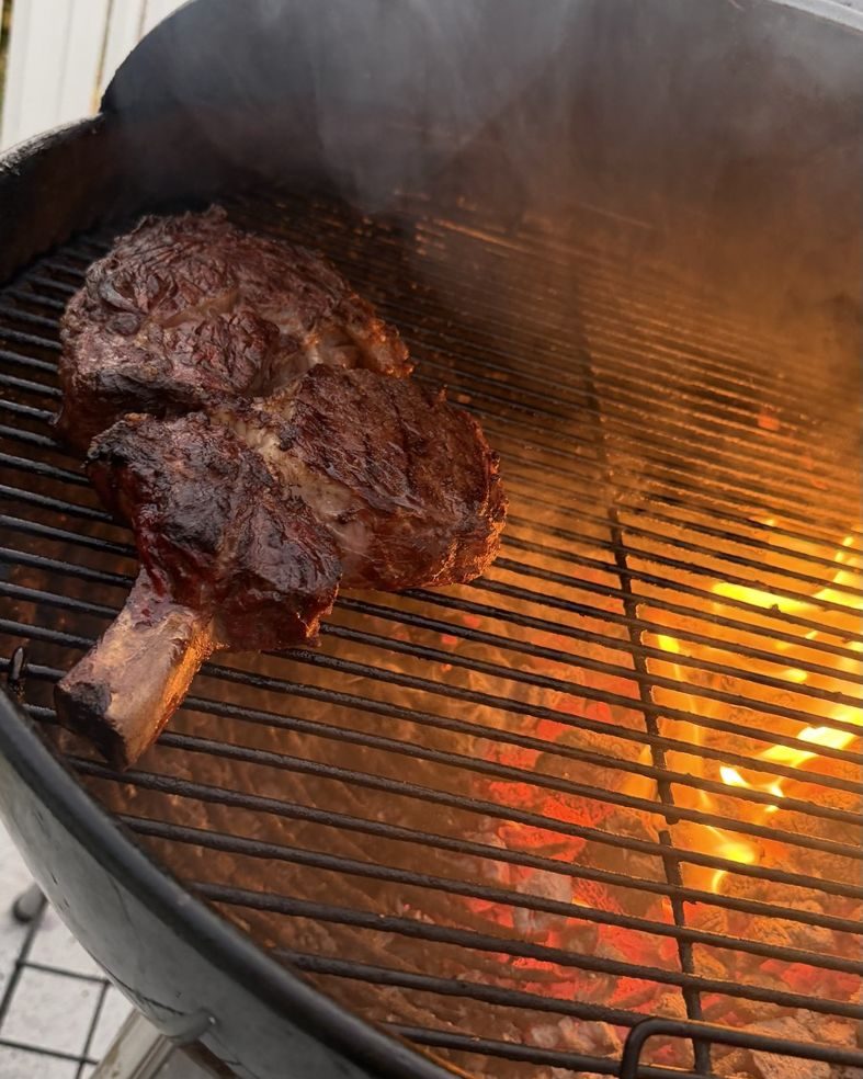 Le tomahawk à côté des flammes, l'os bien visible